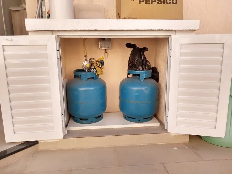 Compartimento para botijões com portas venezianadas brancas