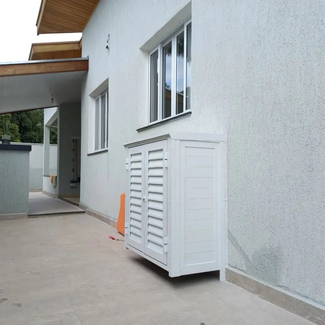 Fechamento branco com portas venezianadas em área externa